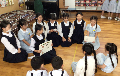 小学生たちが、幼稚園児たちに向けて紙芝居で説明をしている