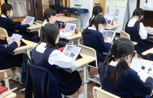 教室で生徒たちがそれぞれ自分のタブレットを使って英語の本を読んでいる